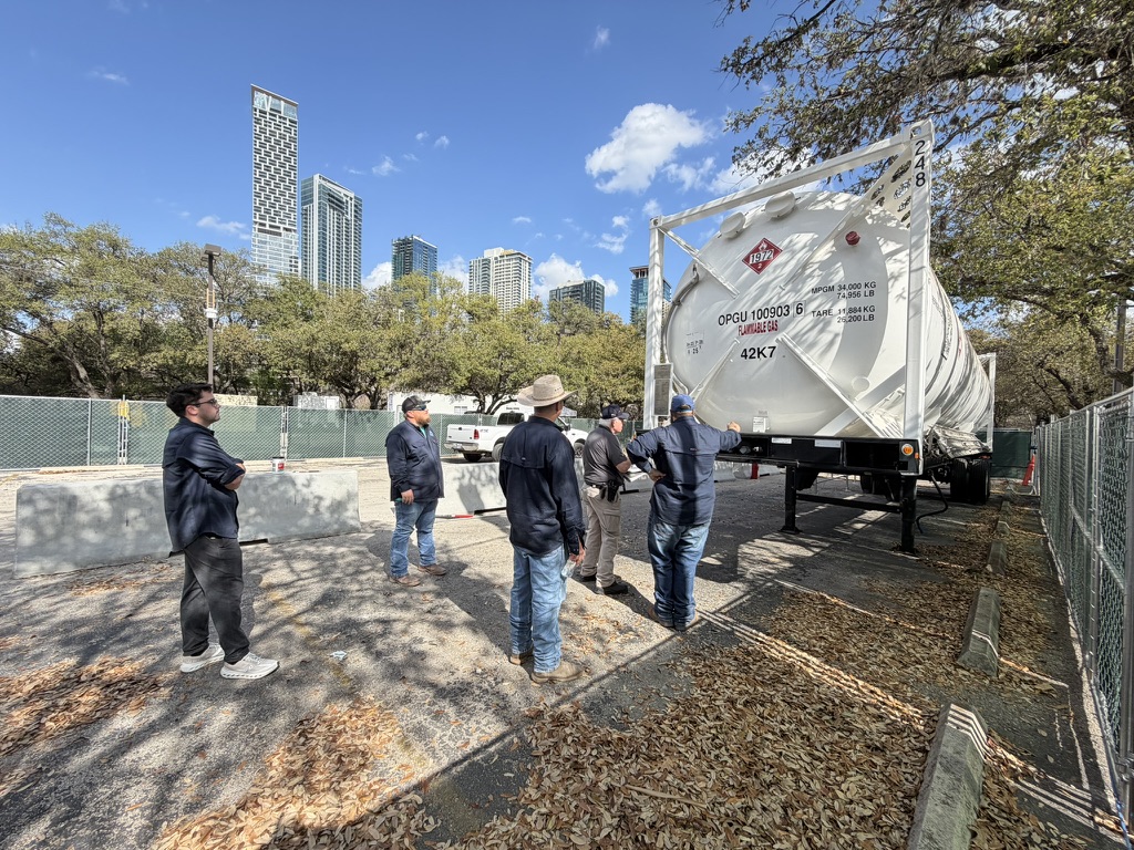 Apollo team with cryogenic ISO tank, Houston skyline